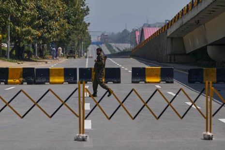 A police officer crosses a barricaded road.