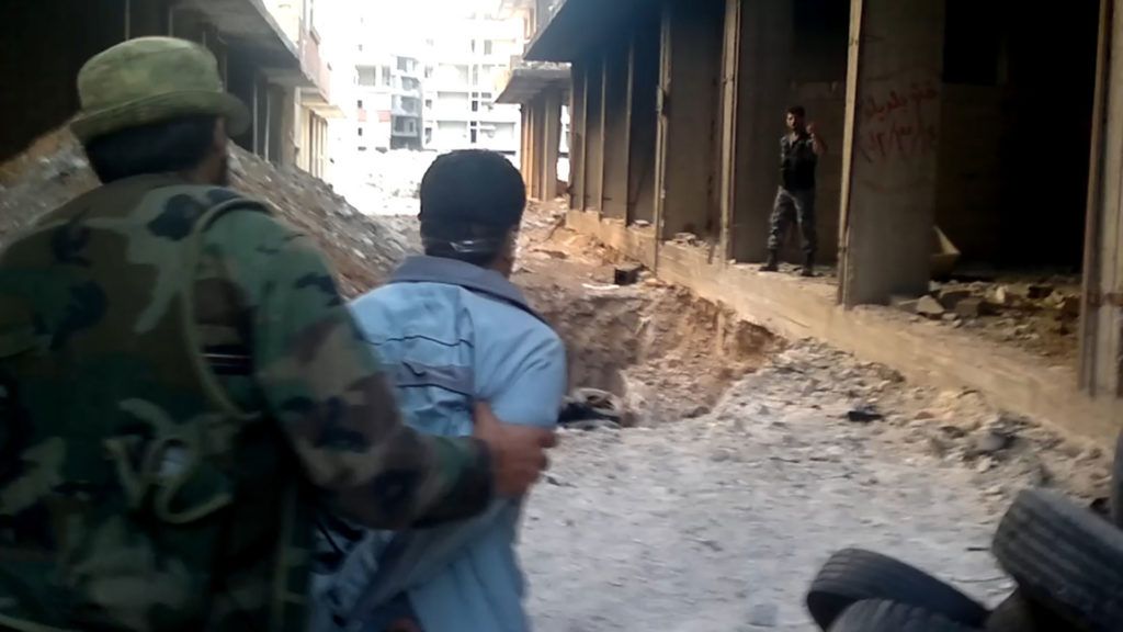 يقود يوسف مدنيًا معصوب العينين ومقيد اليدين إلى مقبرة جماعية محفورة مسبقًا قبل إعدامه