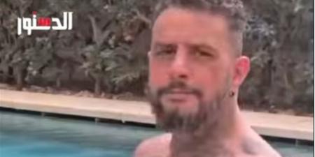 أحمد الفيشاوي يستعرض عضلاته وجسده المليء بـ"الوشم" في حمام السباحة (فيديو)